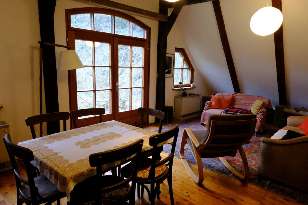 Schönes Zimmer in alter hütte mit Holztisch und Schaukelstuhl, ein egeütliche Couch in der Ecke